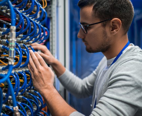 IT professional working on servers and data cables