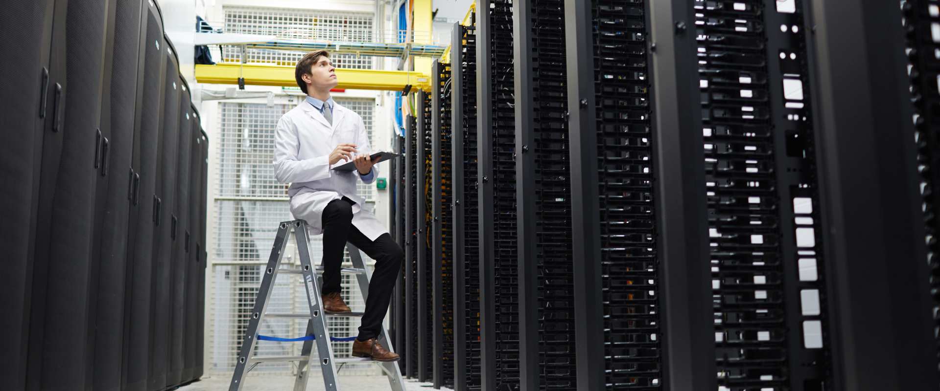 background image of a IT professional sitting next to servers