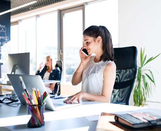 it helpdesken dolgozó nő mosolyog és telefonál